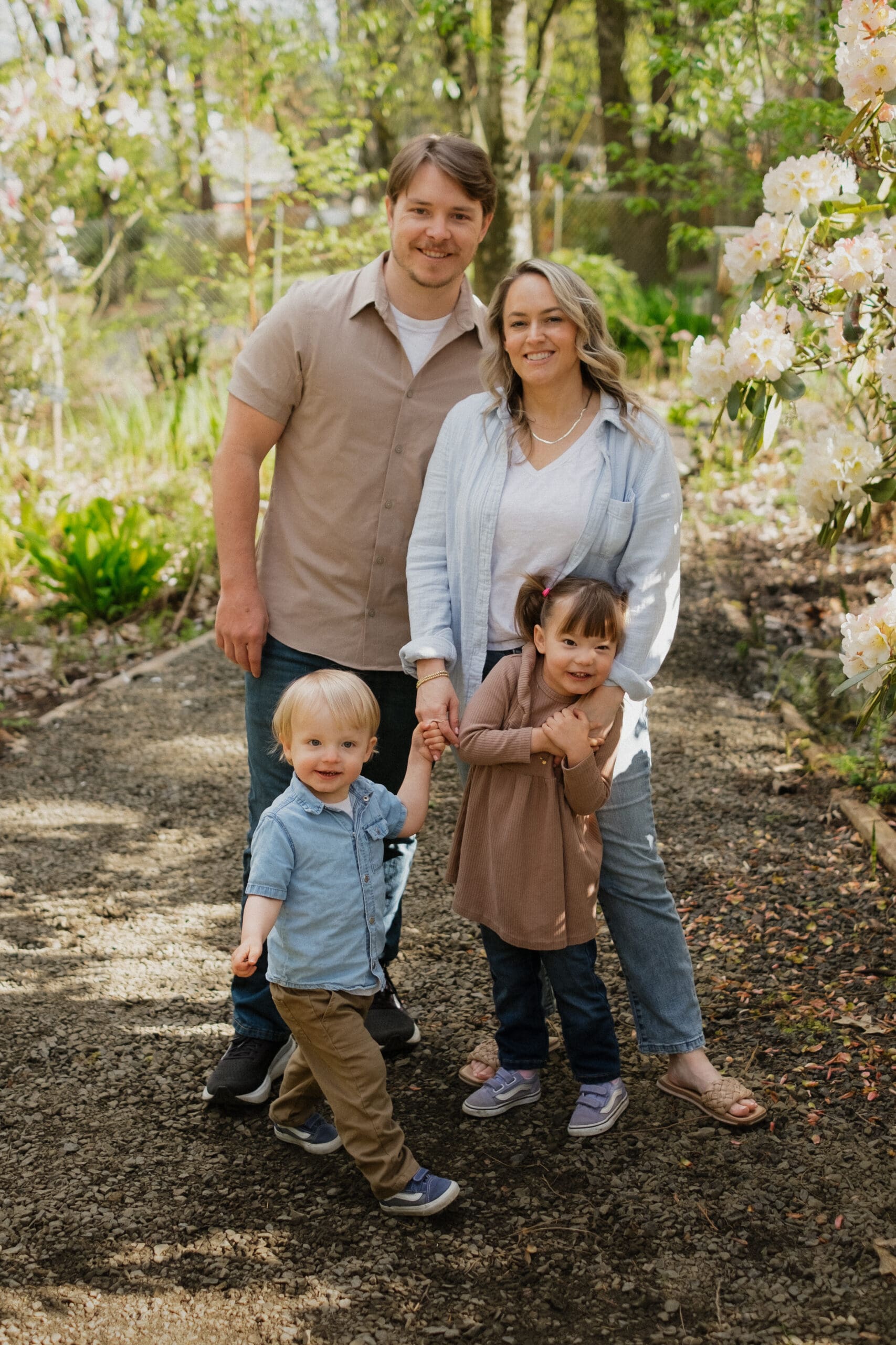 A family standing in front of some flower bushes