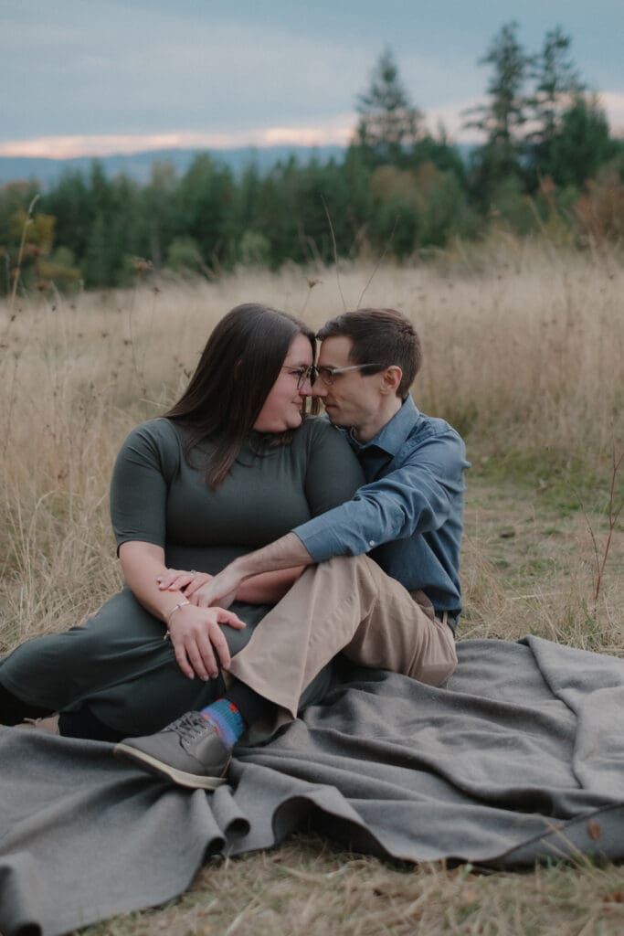 A couple cuddling together on a blanket