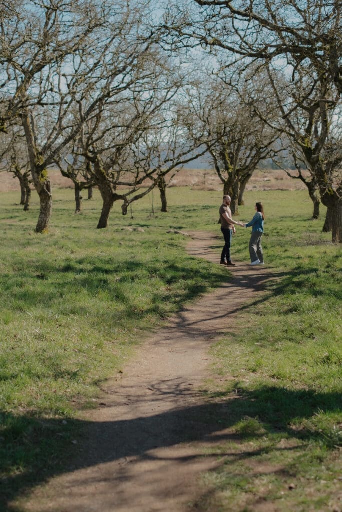 A couple holding hands and walking on a path