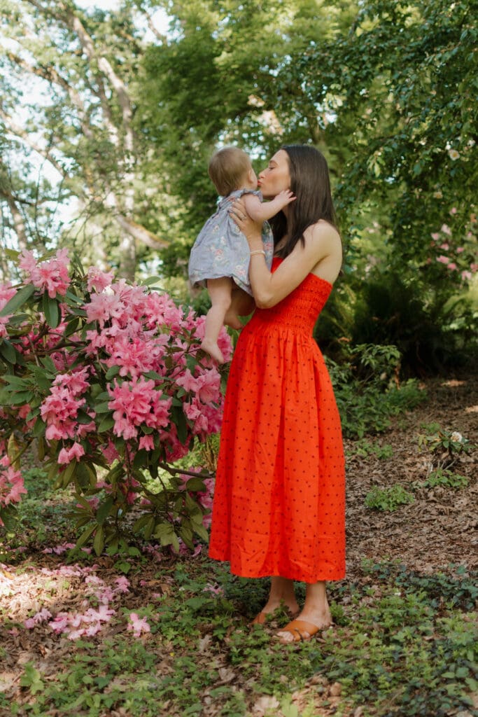 A mother holding her baby and kissing her nose