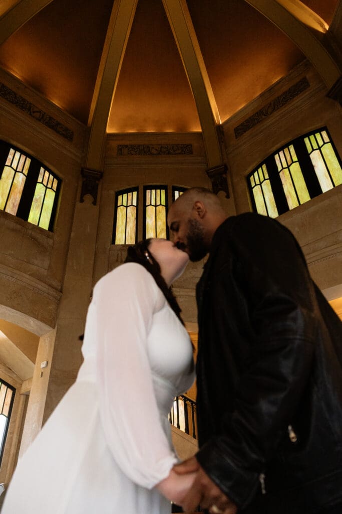 Couple kissing under domed ceiling inside Vista House at Crown Point in Corbett, Oregon.