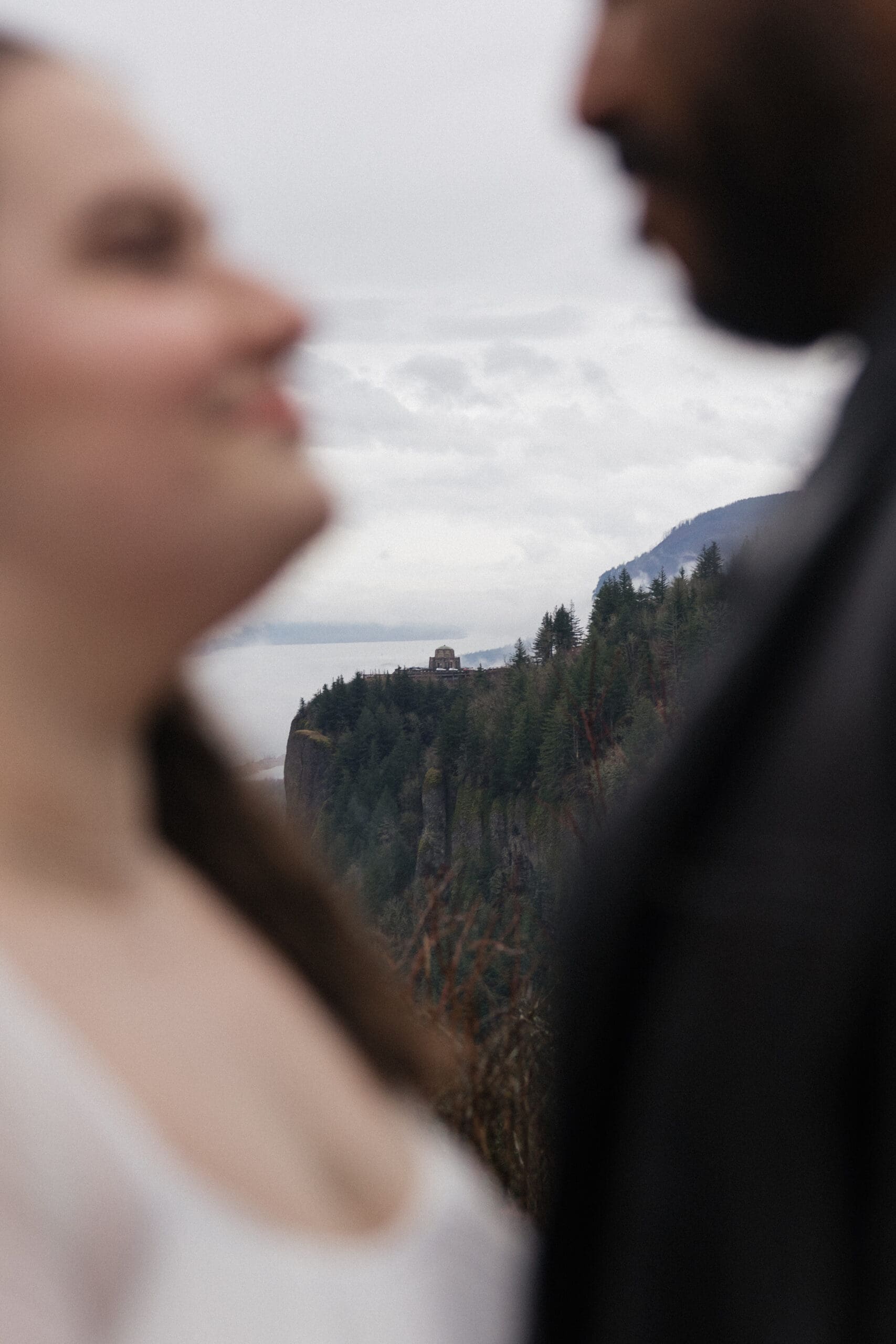 Vista House at Crown Point framed between couple at Portland Women’s Forum State Scenic Viewpoint in Corbett, Oregon.