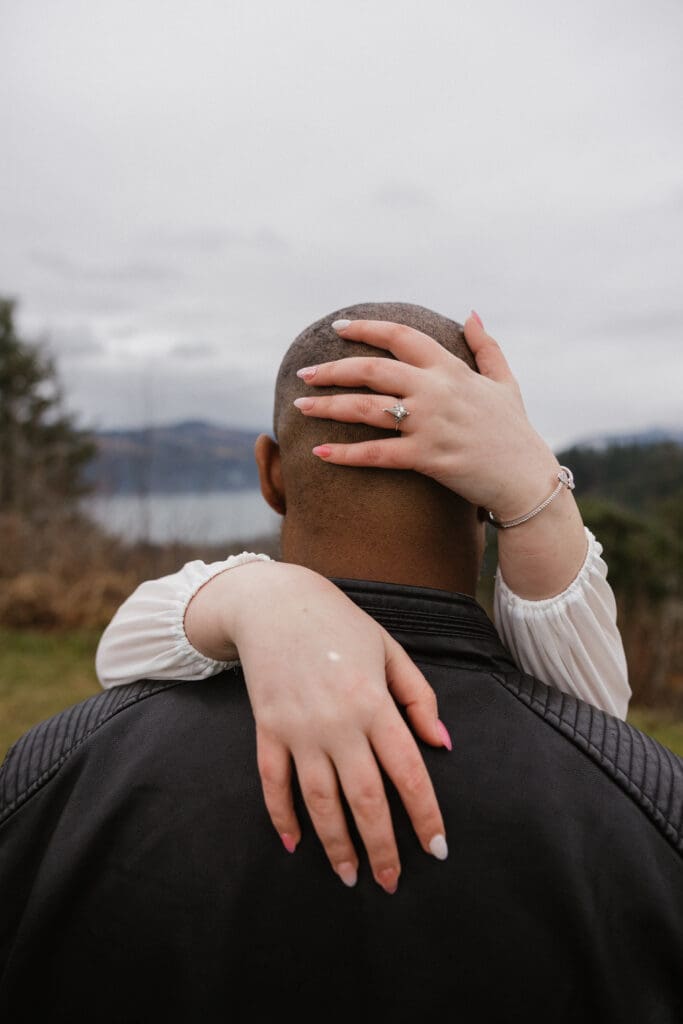 Close-up of engagement ring as partner’s hands rest on shoulders at Portland Women’s Forum State Scenic Viewpoint in Corbett, Oregon.