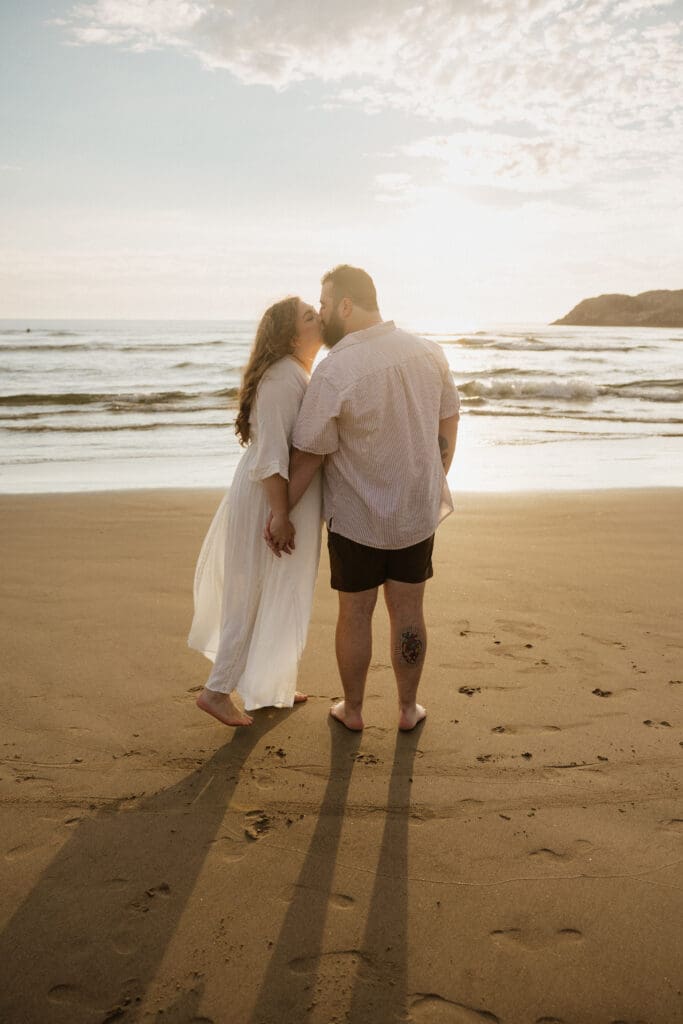 Couple walking barefoot on the beach for Cannon Beach, Oregon coastal wedding planning ideas