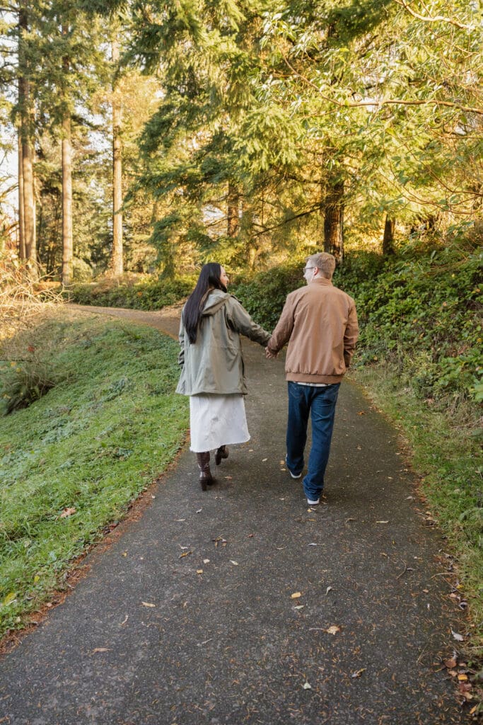 Couple walking through a wooded trail near Portland, Oregon for engagement photo location inspiration