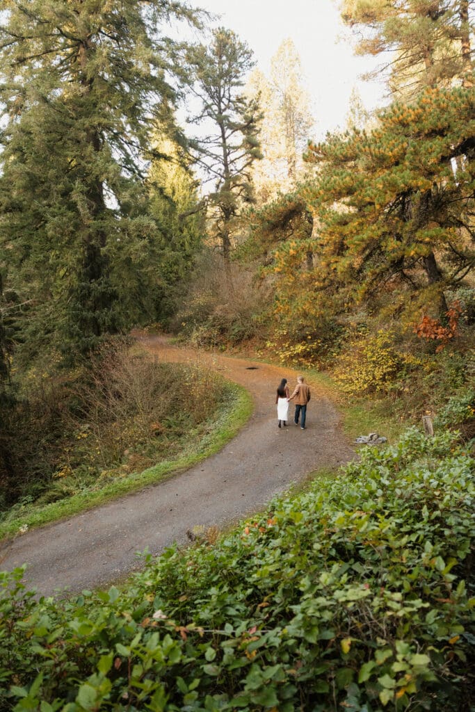 Couple walking along a forest path near Portland, Oregon for outdoor engagement photos