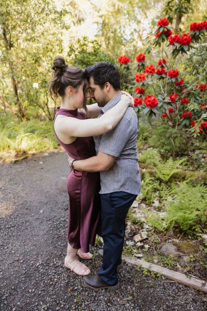 Couple embracing in a garden setting near Portland, Oregon for romantic engagement photos