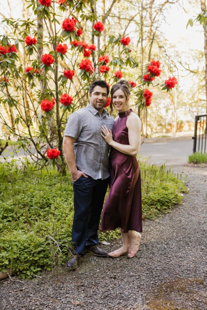 Couple posing beside bright spring blooms near Portland, Oregon for engagement photo inspiration