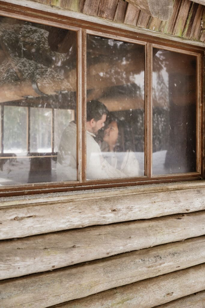 Couple embracing inside a rustic cabin during a snowy Mount Hood engagement session in Oregon