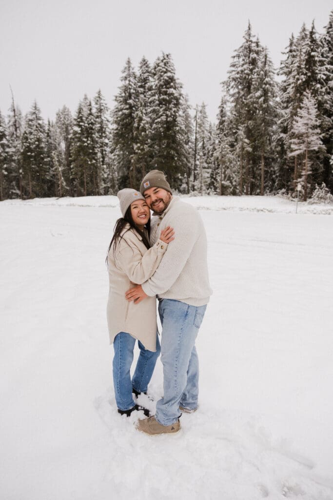 Smiling engaged couple posing in the snow during a Mount Hood engagement session in Oregon