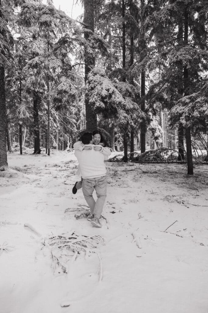 Black and white photo of couple hugging in the snow near Mount Hood in Oregon