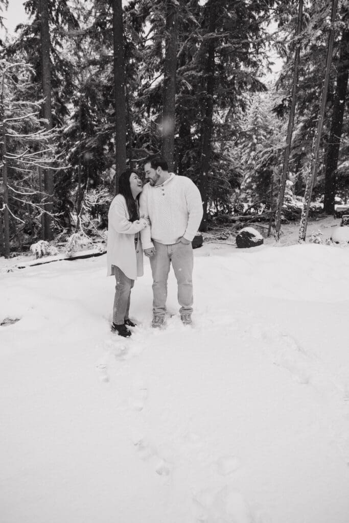 Black and white portrait of couple standing in fresh snow near Mount Hood in Oregon