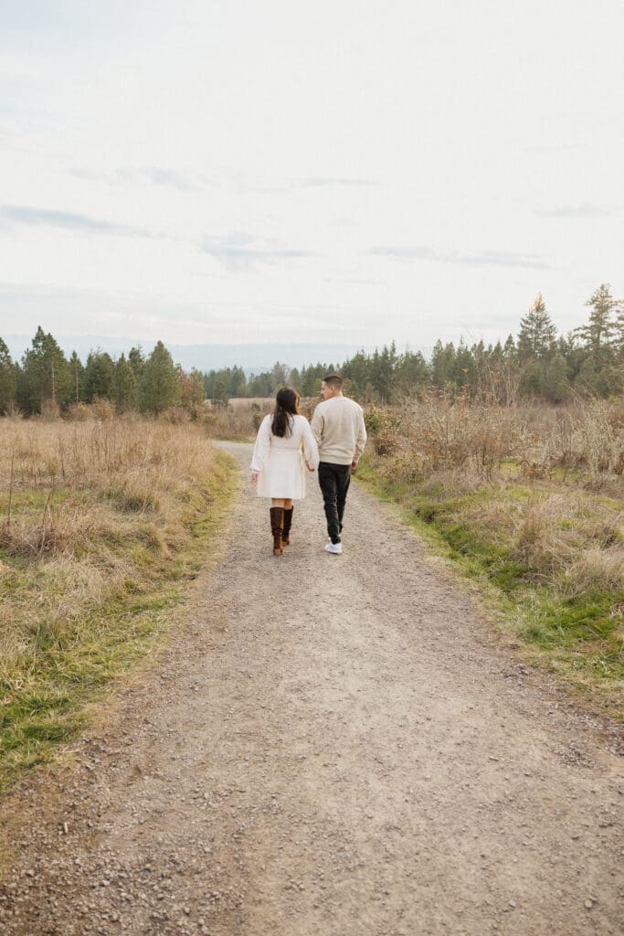 Couple walking along a meadow trail near Portland, Oregon engagement photo locations
