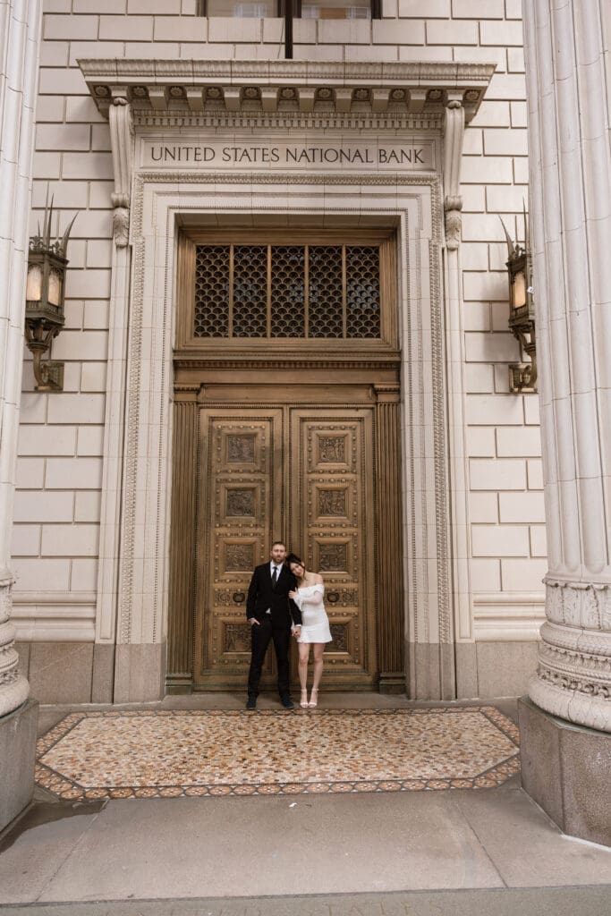 Couple standing outside a historic downtown building for Portland, Oregon wedding planning inspiration