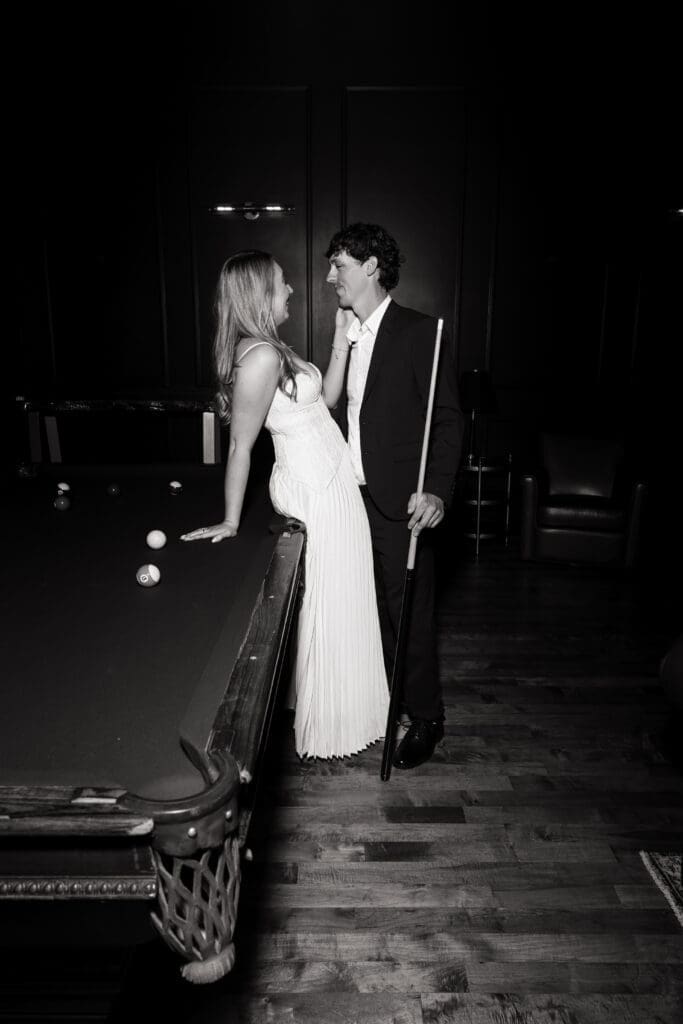 Black and white engagement portrait beside pool table at The Arc Light in Oregon City, Oregon