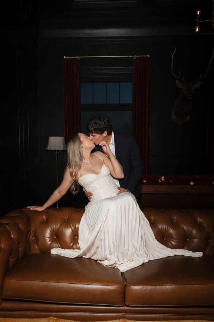 Couple kissing on leather couch at The Arc Light in Oregon City, Oregon