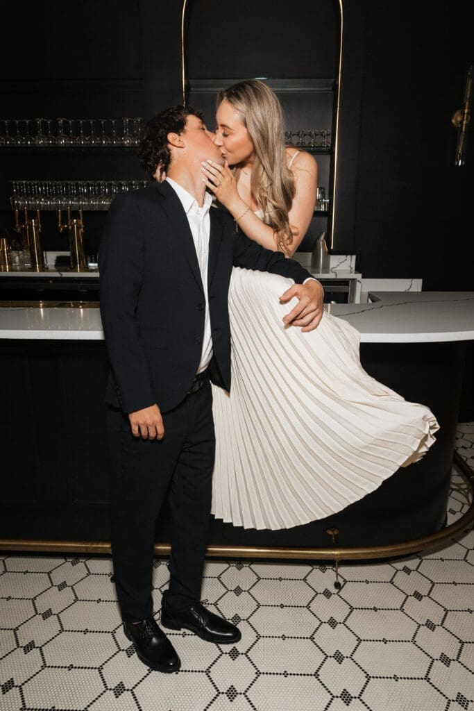 Couple kissing at cocktail bar during engagement session at The Arc Light in Oregon City, Oregon