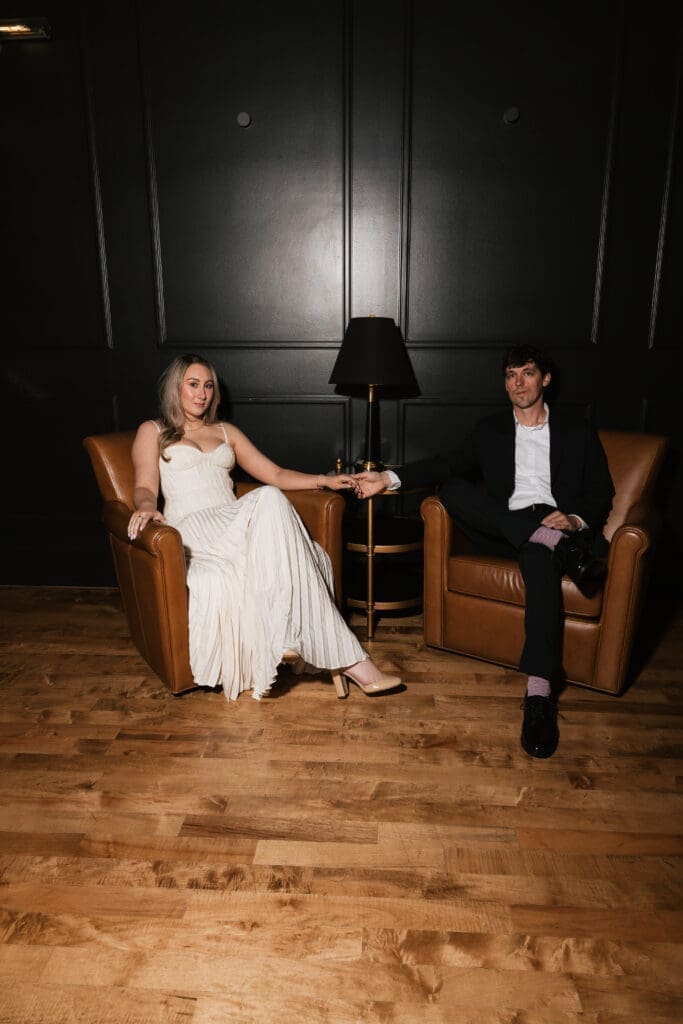 Couple holding hands in leather chairs at The Arc Light in Oregon City, Oregon