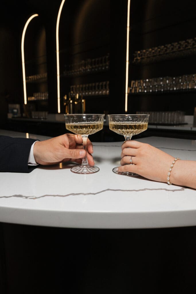 Couple holding coupe glasses at bar inside The Arc Light in Oregon City, Oregon