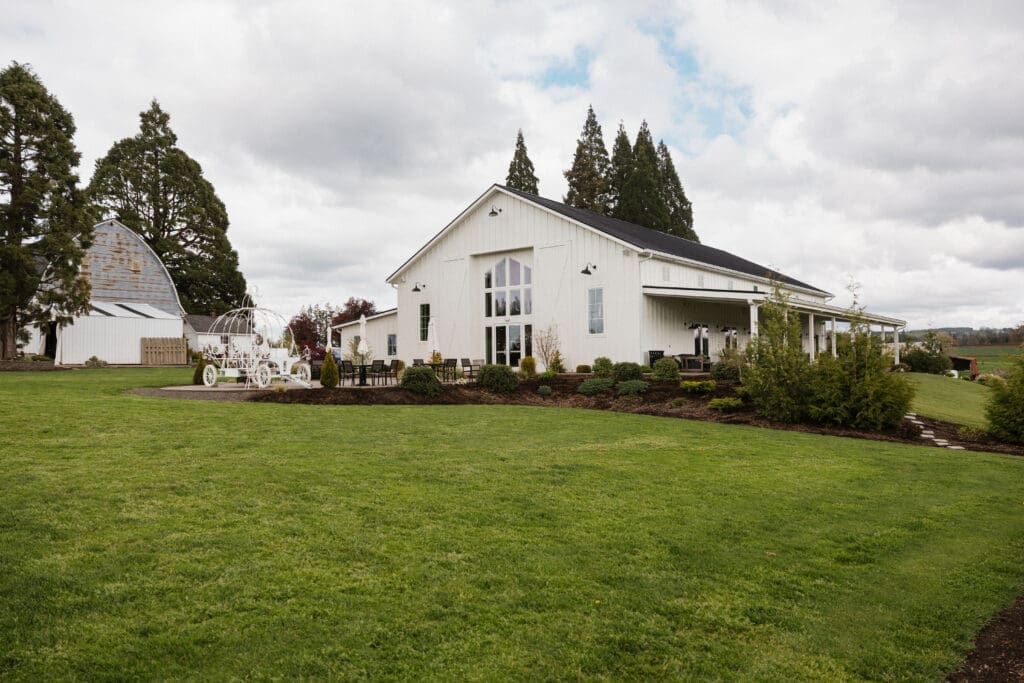 Wide shot of The Farm on Golden Hill event center and covered patio with green lawn in the foreground in Silverton Oregon
