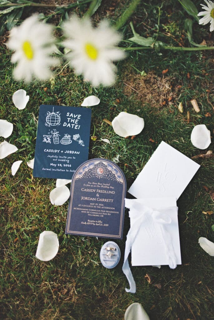 Wedding invitation suite with rings and stationery photographed on film at McMenamins Cornelius Pass Roadhouse in Hillsboro, Oregon.