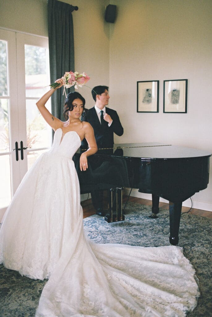 Film photograph of the bride holding a bouquet beside the grand piano at Black Walnut Inn in Dundee, Oregon.