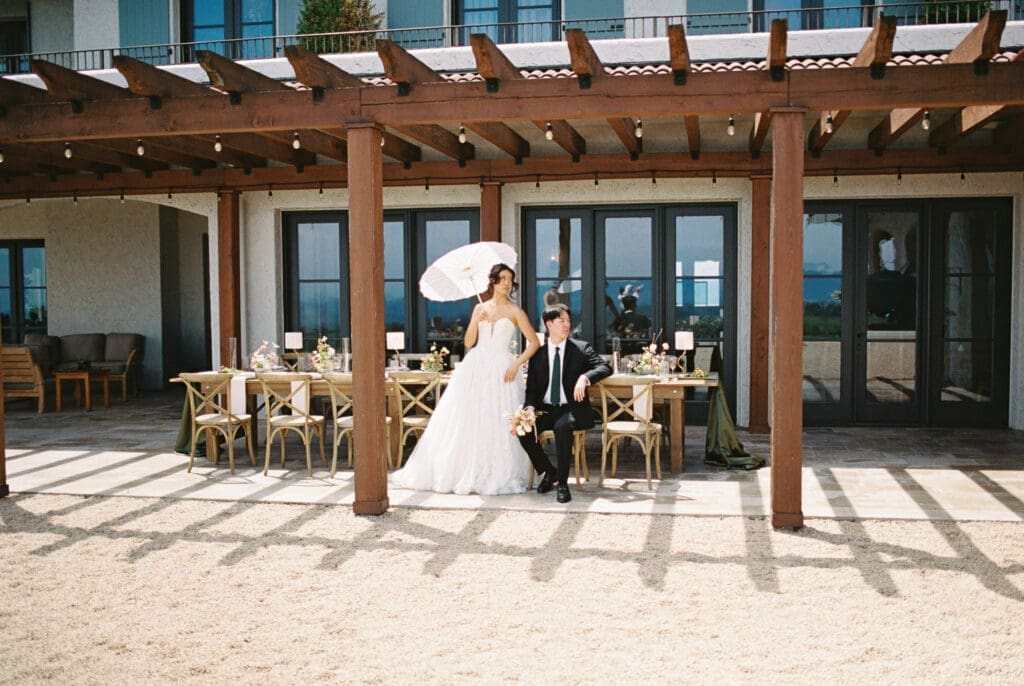Bride and groom posing beneath the pergola reception space during a film wedding editorial at Black Walnut Inn & Vineyard in Dundee, Oregon.
