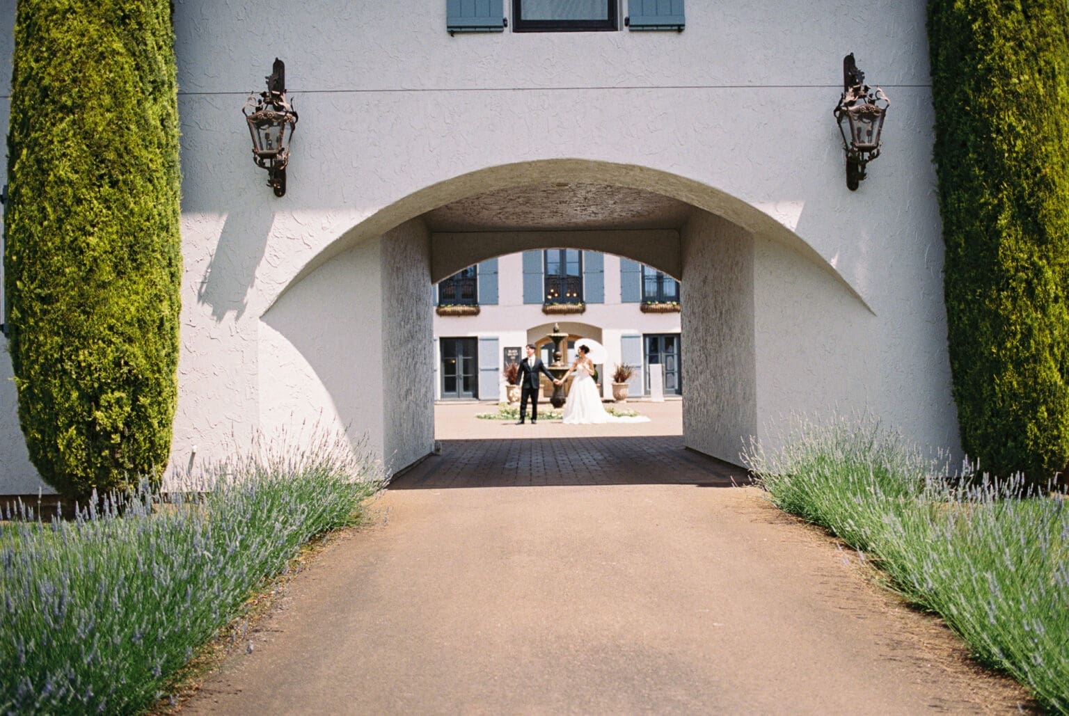 Film photograph of the couple framed beneath the entrance archway at Black Walnut Inn in Dundee, Oregon.