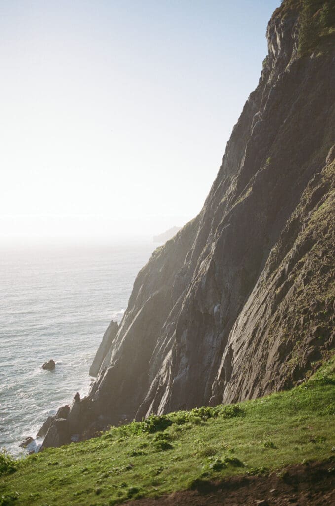 Sunlit coastal cliffs overlooking the Pacific Ocean at Cannon Beach, Oregon, photographed on film.