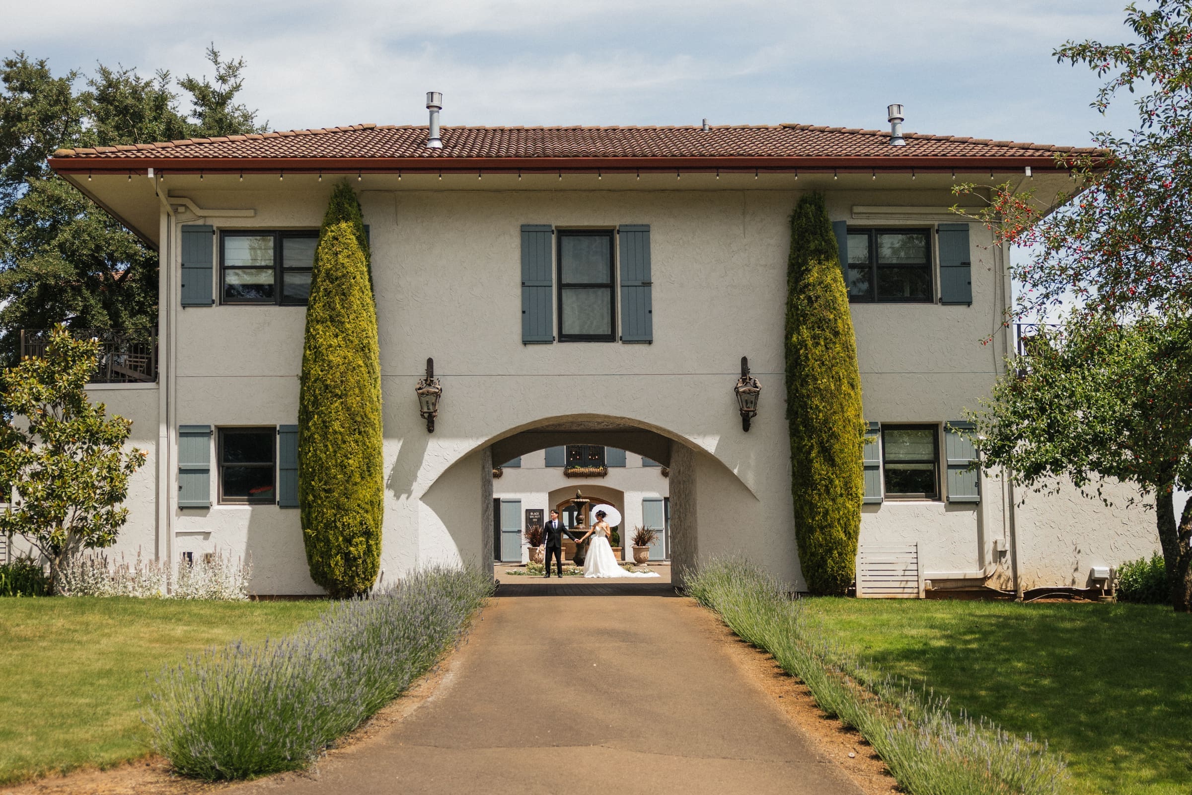 Couple framed beneath the entrance archway at Black Walnut Inn in Dundee, Oregon.